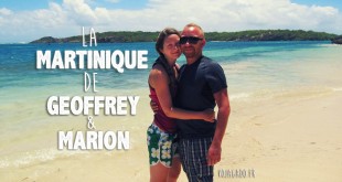 Geoffrey et Marion, un jeune couple qui vit en Martinique, se tient debout devant la mer des caraïbes en souriant sur une plage de cette île française des Antilles