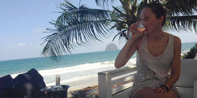 Marion est assise dans un restaurant sur la plage en Martinique face au célèbre rocher du Diamant