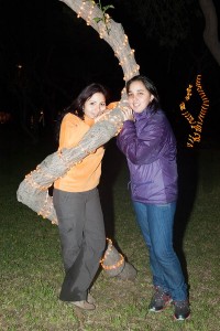 Sharon et sa cousine posent accrochées à un palmier, de nuit, dans un parc de Lima au Pérou