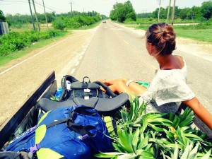 Jeanne est assise dans une petite carriole qui transporte des ananas, sur une route de Belize, en Amérique centrale