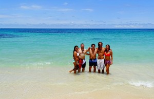 Jeanne et Stefenn sont avec des amis, les pieds dans l'eau, sur une plage de sable blanc du Panama en Amérique Latine